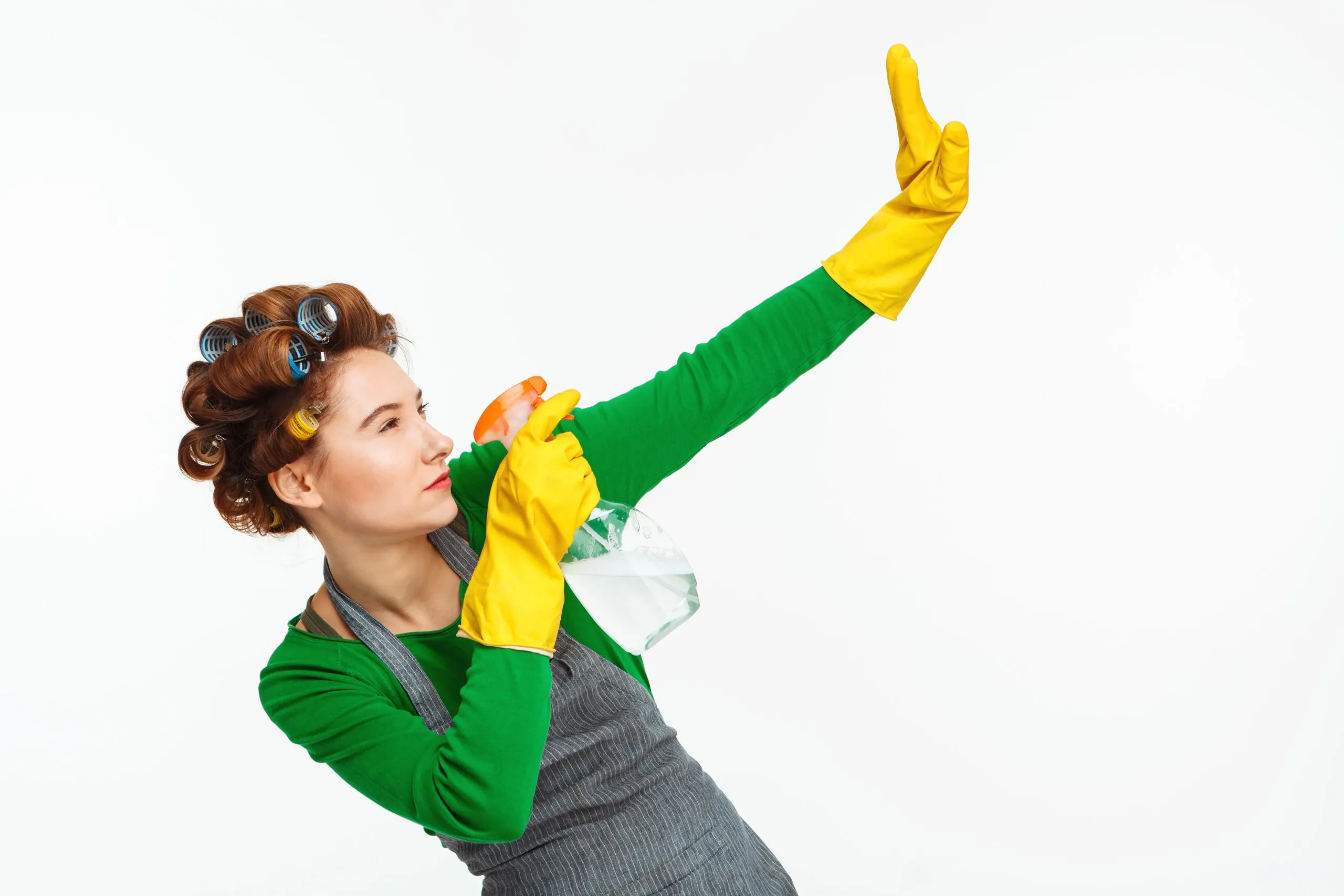 Woman spraying windows and posing with yellow rubber on hands
